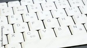 Man sanitizing, disinfecting, cleaning a white laptop keyboard extreme closeup, hand using a wet disinfectant wipe, damp tissue to disinfect, sanitize and clean a notebook, wiping an electronic device