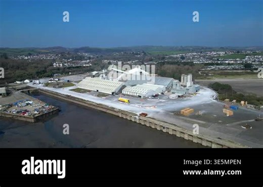 Par, Cornwall, England: DRONE VIEWS: Par Docks with the town of Par and Par Sands beach in the background. The Docks is a milling centre and also receives a slurry form of china clay for transporting to nearby Fowey Stock Video Footage - Alamy