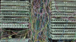 Inside a PABX telephone booth that has a number of connecting cables in many colors in the analog system. communication technology