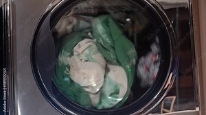 Washing machine wash dirty colorful clothes Wash clothes in a domestic washing machine. A close view of a drum washing machine Coin laundry shop. Stock Video