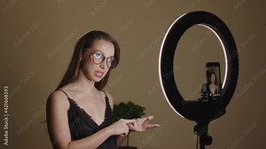 Young smart woman female blogger streaming at home, recording online webinar, pretty influencer talking on camera, filming news, consulting, broadcasting, psychologist vlogging concept. Lifestyle