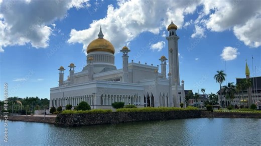 Brunei Darussalam - June 25, 2025: Sultan Omar Ali Saifuddin Mosque in Bandar Seri Begawan. Mosque with reflection in the pond. The mosque's facade and dome are illuminated by sunlight. 4K