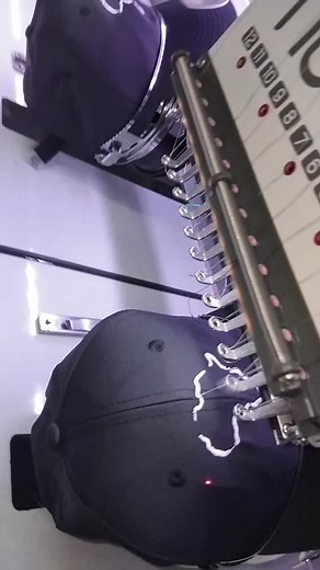 Embroidery Machine in Action on Black Caps