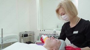 Ultrasonic massager. Light skin treatment. A woman in a beauty salon undergoes a course on facial skin rejuvenation.