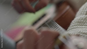 Ukulele in female hands. A woman learns to play the ukulele at home while sitting on the couch. The girl plays the ukulele on a small guitar and sings. Hobby and musical string instrument concept. Stock Video