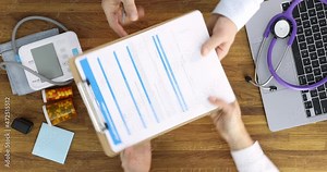 Doctor fills out health insurance claim form for payment