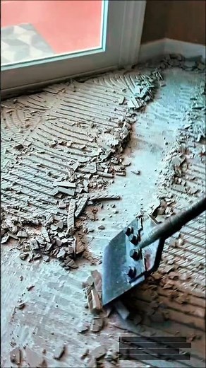 Removing Old Tile Adhesive from Floor Using Heavy-Duty Scraper Tool