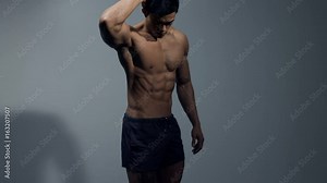 Asian fitness model flexing abs with hand behind head.