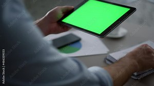 Man hands using tablet device green screen research business finance in office.