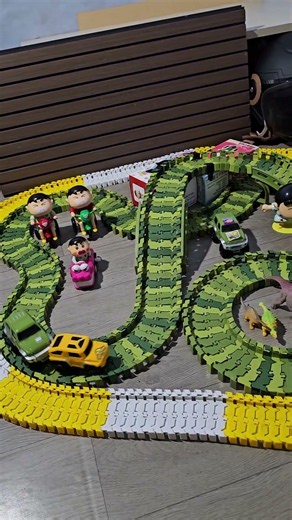 Yellow car pushed by green toy car in dino arena