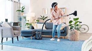 Playful cleaner singing and dancing while cleaning the house on a weekend. Young jolly woman doing housework with a vacuum and using it as a guitar and mic at home. Joyful female enjoying her chores