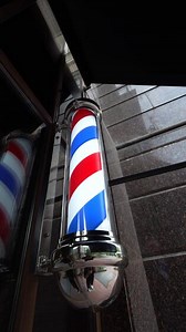 Barber pole signage at a local barbershop in urban setting