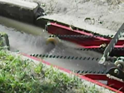 Hydroscreen,inc. A model water drive trash cleaner in a irrigation ditch running.