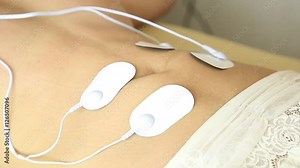 professional electrotherapy on woman body. muscle contraction under the influence of an electric current. close-up patient's stomach