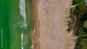 South Africa JBAY Jeffreys Bay aerial drone town homesmost stunning white sand beach epic surf wave saturated aqua blue rugged reef coastline daytime people on beach with umbrellas summer looking down