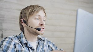 Call center male operator with headset talking with client in agency