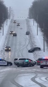 Car Slides Uncontrollably Down Icy Hill, Triggers Chain of Crashes Below Akron, OH — A steep city street turned into a frozen chute when a car lost traction on an ice-covered hill and slid helplessly downhill, crashing into multiple vehicles already piled up at the bottom as police struggled to control the scene. Video from above shows cars creeping cautiously down the slope, tires carving faint tracks into the ice with little effect. One vehicle suddenly begins sliding sideways, spinning as gra