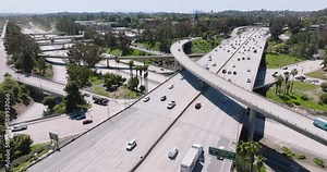 Drone aerial of traffic congestion on freeway and bridge, complex highway infrastructure with themes of transportation, rush hour. Aerial drone rotational video of modern multilevel junction.