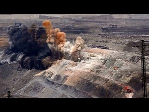 Vast open pit mine with Hitachi excavator and dump truck at work