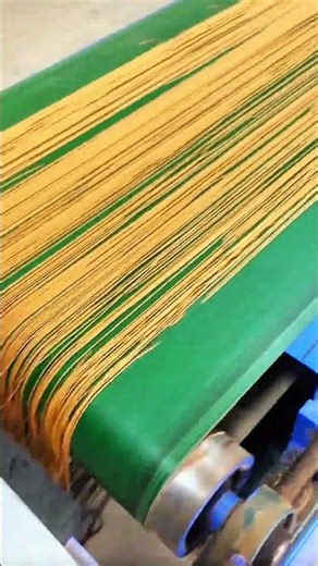 Threads stretched, machine humming in silence