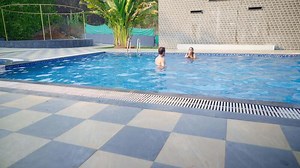 Lovers are playfully swimming at resort pool