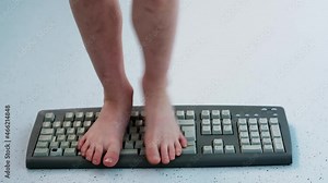 child stands, jumps, dances with his feet on computer keyboard, presses buttons, little vandal, bully plays with gadget, bullying concept, spoils technology until parents can see