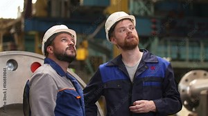 two engineers discuss important stages of construction in heavy industry factory