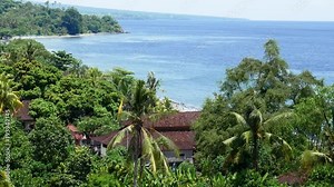 landscape nature tropical island with rocky mountains overgrown dense green jungle tree, palm and water of sea ocean