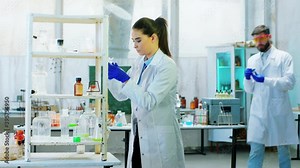 Chemistry laboratory two scientist woman and man together working on a experiment using different chemical liquid for this very concentrated working