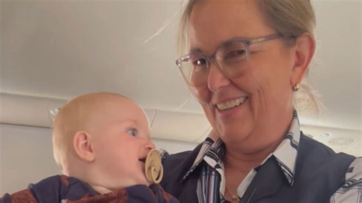 Super compassionate flight attendant helps calm passenger's baby down mid-flight