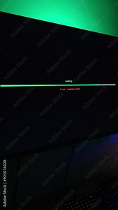 Vertical video. Dark Room with Computer Setup, Monitor Displaying Loading Bar and "Error: Loading Failed" Message in Red, Creating a System Error Atmosphere.