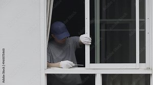 Handyman repairing the sliding window. Adjust a rail wheel and lock hook.