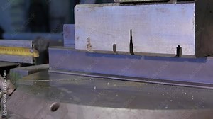 Press presses metal profile. Press presses steel bar. Sheet of metal and hands of worker who works on press. press clamps aluminum bar or profile. Preparation for cutting metal.Machines for the