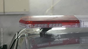 Emergency vehicle lighting installation. Mounting police red blue emergency LED light bar on top of the car.