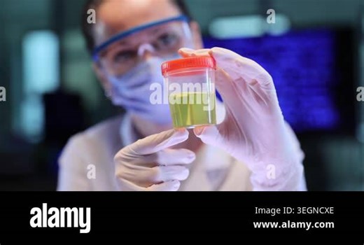Woman scientist holds clear cup with yellow liquid in lab. Gloved hands turn sample container checking color before careful testing work slow motion Stock Video Footage - Alamy