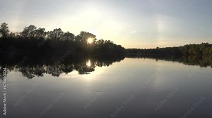 Unusual atmospheric phenomena. Very bright double halo (parhelic ring) over river at moment of evening sunset, windless spring day. Average flow of Don River. Mock sun with reflection in water