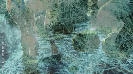 Woman wading and cupping water, sparking blue light trails growing across rocky shore for design