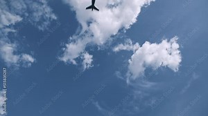 Plane takes off from airport and flies overhead. Front view passenger airplane gaining altitude in blue sky and approach landing direction light in front of camera. Cinematic shot, daylight, sunny day
