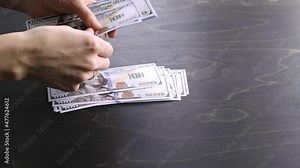 4K. The woman counts the money. 100 USA dollar banknotes bundle. Counting process. World economic crisis. Bribe. Dirty money concept. Puts on wooden table. Side view. Close-up. Hundred. Video footage.