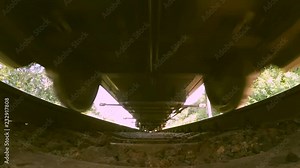 Passing train bottom under view wide angle close-up. Railroad tracks railways train transport system fast speed