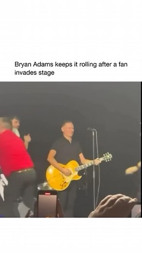 Good Music on Instagram: "During a July 2023 concert in Salt Lake City, Bryan Adams was performing Summer of ’69 when a fan suddenly rushed the stage, grabbed the mic, and sang a line before security stepped in. Adams remained unfazed, stepping back and letting security handle the situation while seamlessly continuing the performance. Later, he shared a clip of the incident on social media with the caption, “Sometimes you just gotta laugh,” showing his good humor about the unexpected moment."