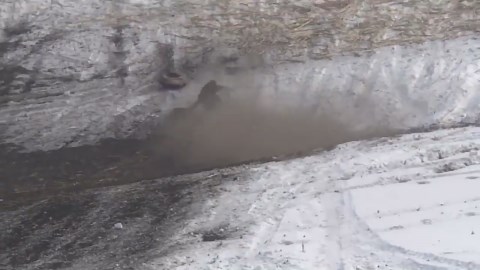 Two men enjoy playful tire sledding in heavy snow in Heilongjiang, China