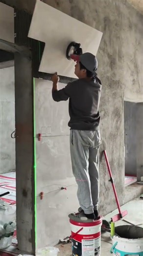 Skilled Construction Worker Installing Large White Wall Tiles Using Suction