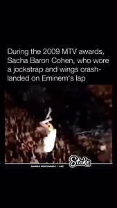 609K views · 3.3K reactions | During the 2009 MTV Video Music Awards, Sacha Baron Cohen, dressed as his character Brüno in a jockstrap and angel wings, staged a stunt where he crash-landed on Eminem’s lap from above. The incident, meant as a comedic bit, sparked controversy when Eminem stormed out, though it was later revealed to be partially staged. | Historyinmemes | Facebook