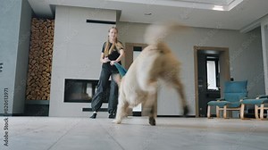 A child dances with a mop, her dog runs nearby. Fun cleaning