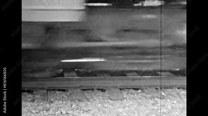 Close up, railway train in motion, black white film. Archival video of old railroad driving by transportation track. Train wheels pass at high speed on countryside. Abstract archive. Retro 1980s