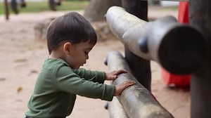 Asian child smiling playing on slider bar toy outdoor playground, happy preschool little kid having funny while playing on the playground equipment in the daytime in summer, Little boy climbing