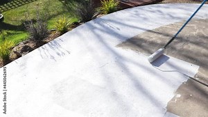 painting backyard or driveway concrete paving with paint roller, DIY and home improvement