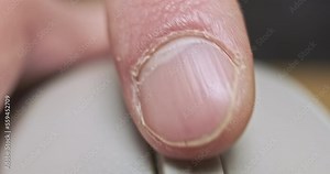 Finger scrolls the mouse wheel. Close-up, macro, front view. Dirty computer mouse wheel.