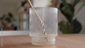 Time lapse drinking a green healthy juice through a sustainable golden metal straw from a design drinking glass in the living room at home. 4K Zoom-In Detail